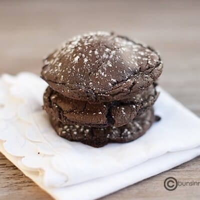 A close up of a stack of chocolate cookies on a napkin.