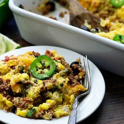 Cornbread casserole in a plate with a sliced japaeno on top.