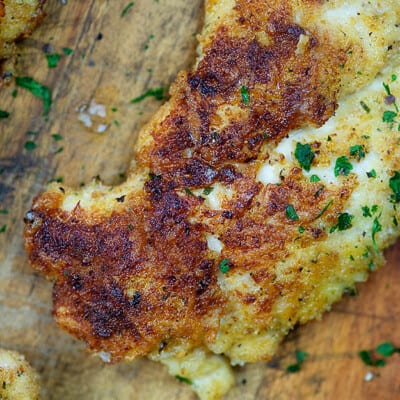 Chicken breast on a wooden cutting board.