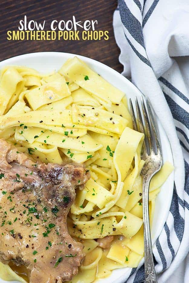 Porkchop and noodles on a white plate.