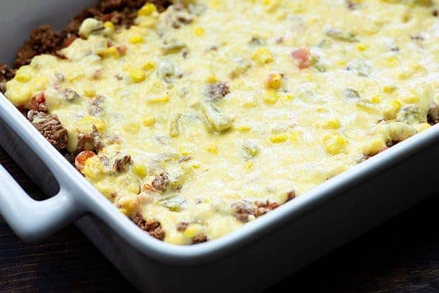 mexican cornbread over taco meat in white dish