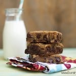 Three chocolate chip cookie bars stacked on a folded cloth napkin