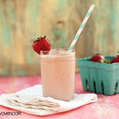 A strawberry milkshake in a glass jar