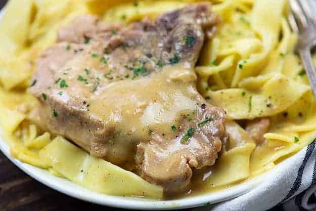 slow cooker pork chops on white plate.