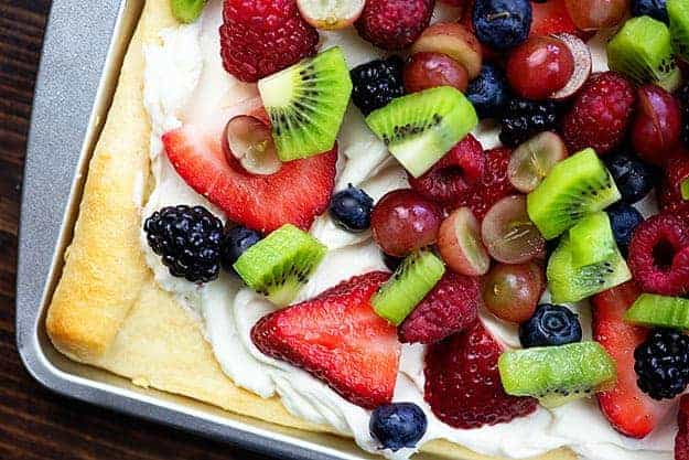 cream cheese fruit pizza on baking sheet