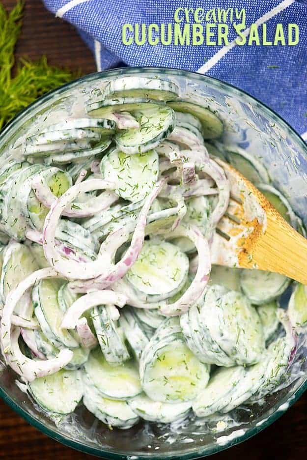 Cucumber salad in a large clear glass bowl.