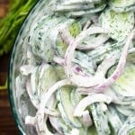 Cucumber salad in a clear glass bowl.