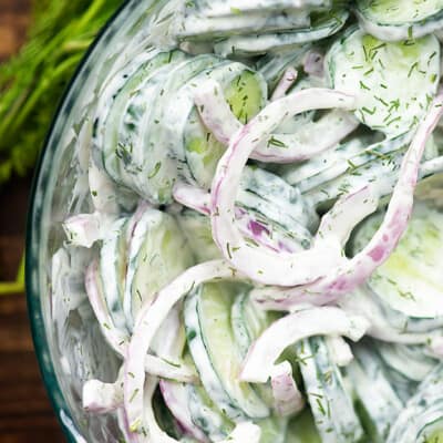 Cucumber salad in a clear glass bowl.