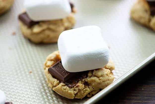 marshmallows on top of cookies on baking sheet
