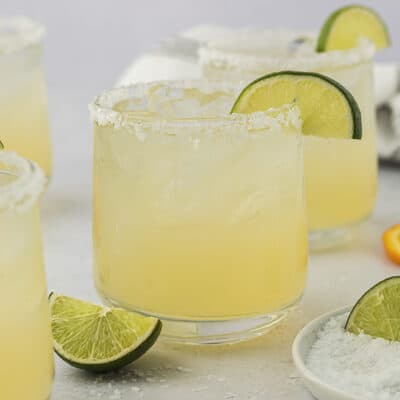 Margaritas in glass with salted rim and lime slice.