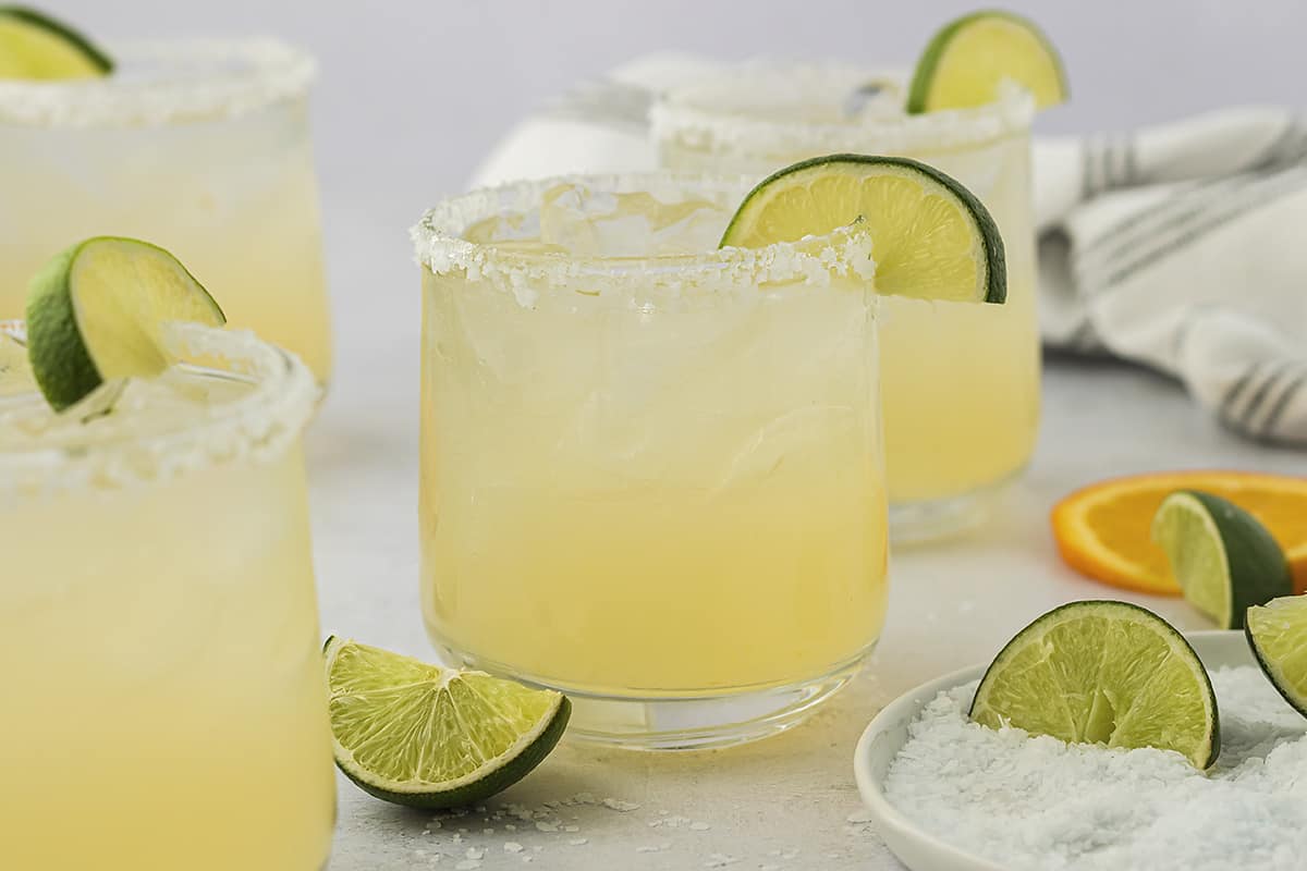 Margaritas in glass with salted rim and lime slice.