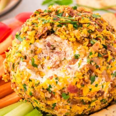 Bacon ranch cheese ball surrounded by vegetables and crackers.