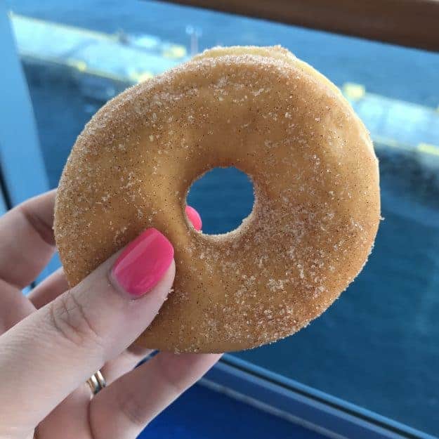 A sugar donut in front of a window.