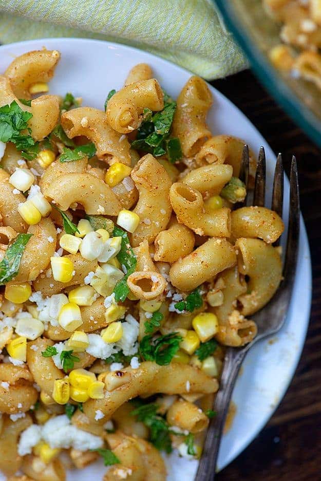 A close up of pasta salad on a white plate.