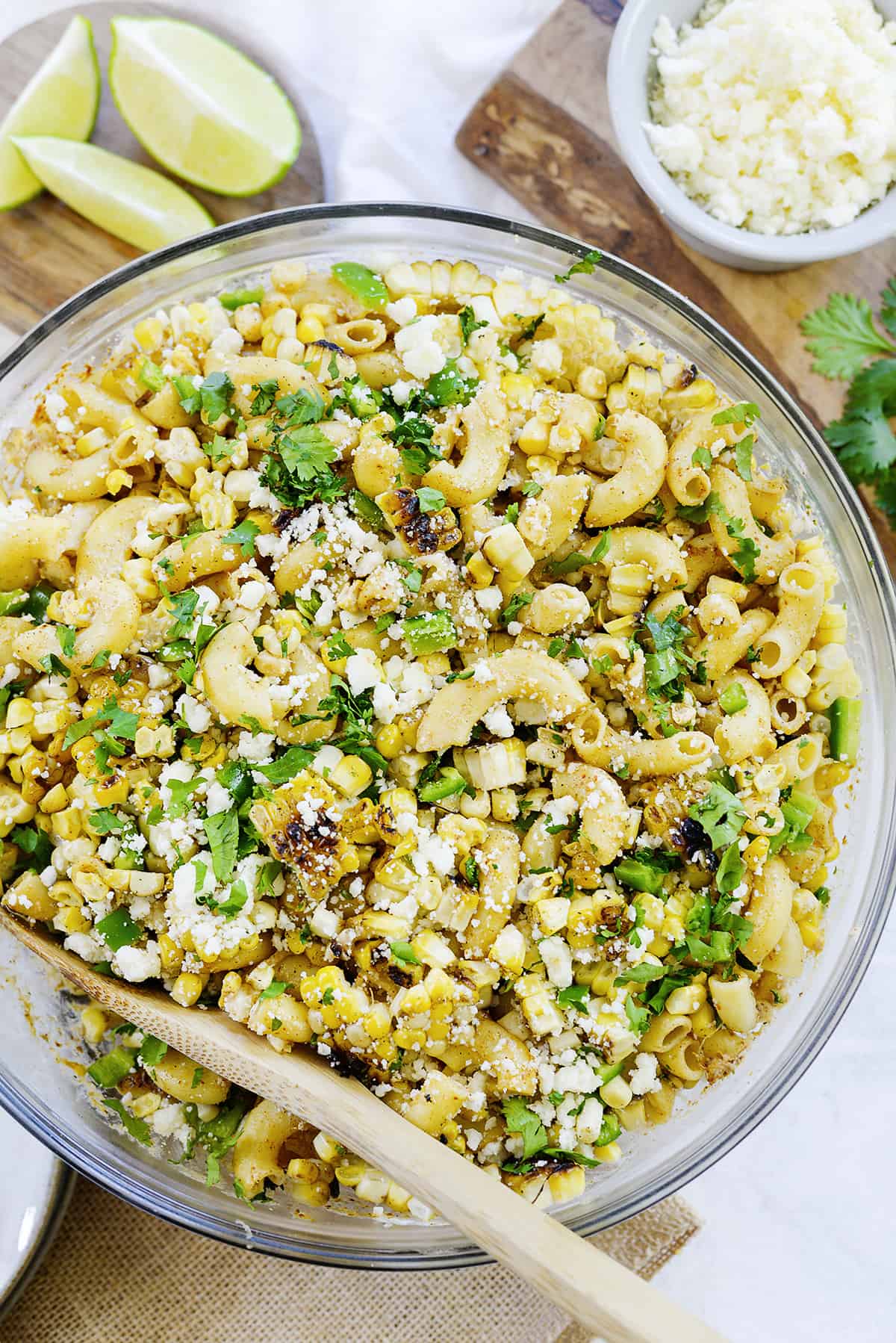 Bowl of Mexican street corn pasta salad with wooden spoon.