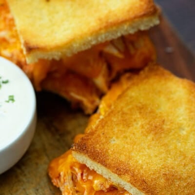 A grilled cheese sandwich on a cutting board.