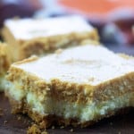 A square of pumpkin cheesecake with a bite taken out of it.