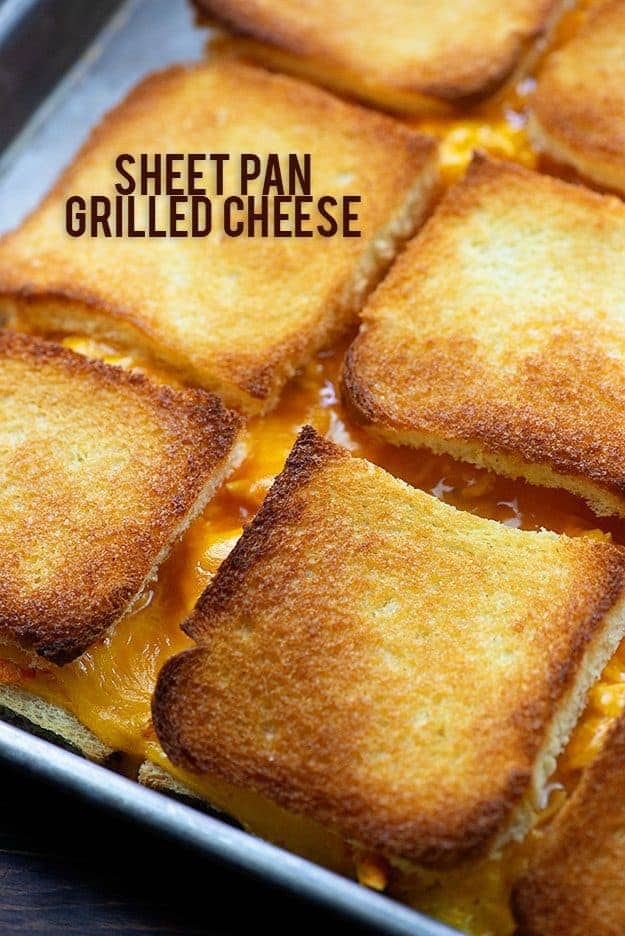 Several grilled cheese sandwiches on a baking sheet.