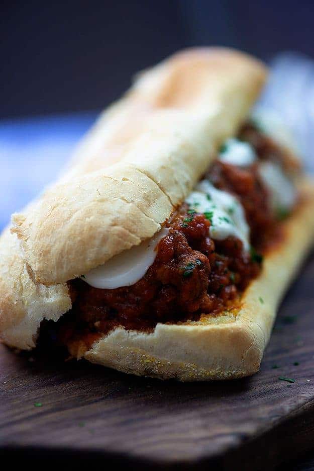 Meatball sandwich on a cutting board.