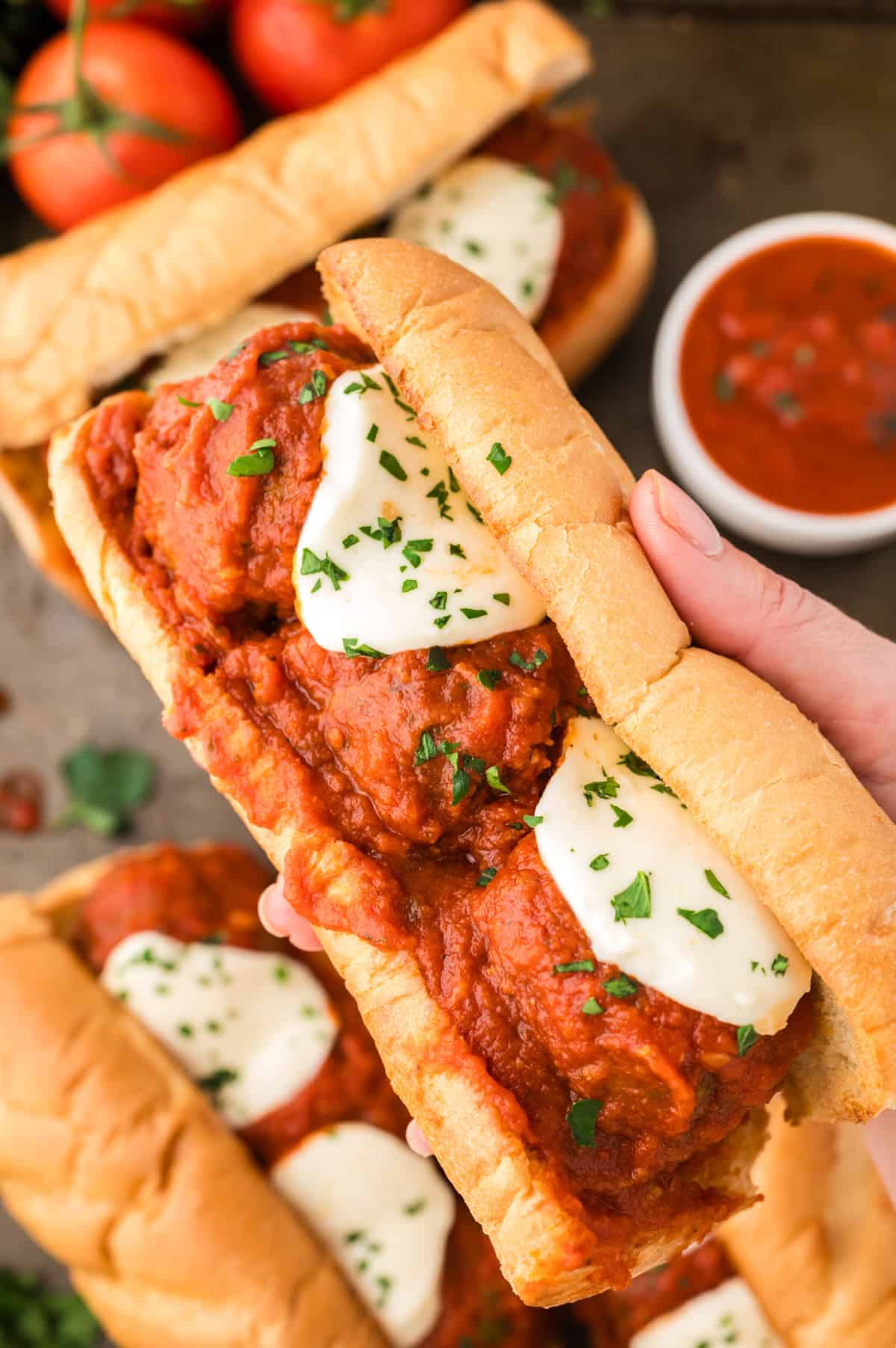 Hand holding a crockpot meatball sub.