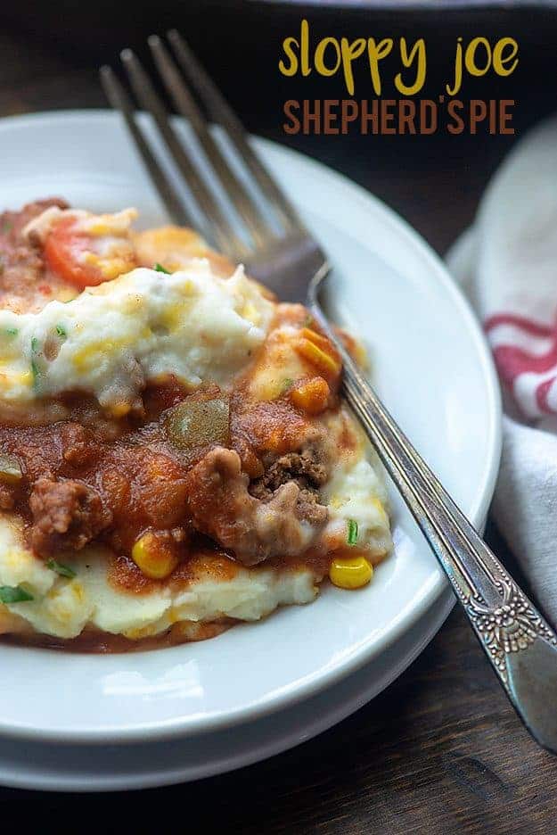 A close up of a plate of shepherds pie with a fork.