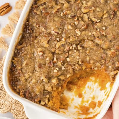 Sweet potato casserole in a white pan on a cloth napkin.