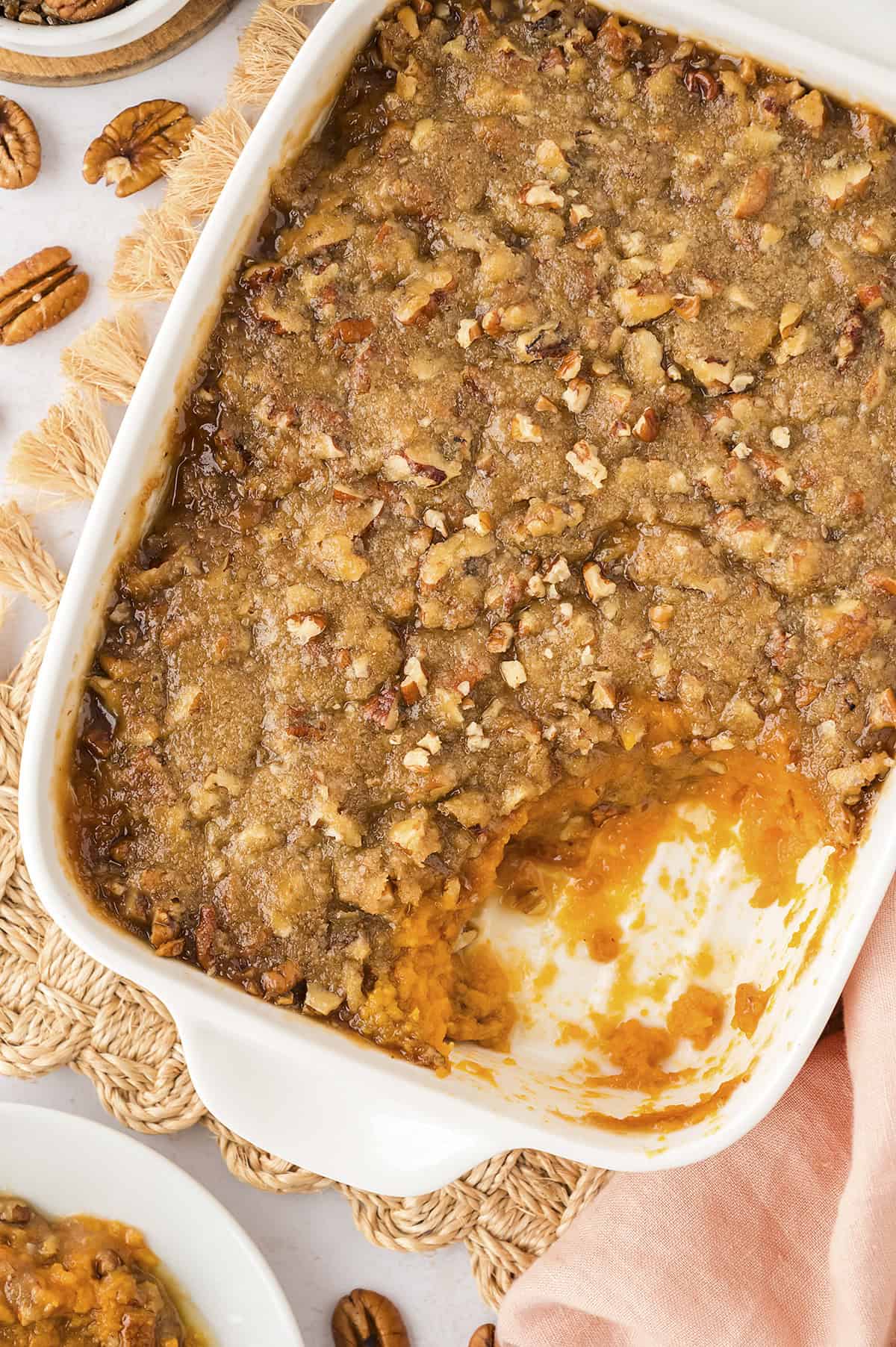 Sweet potato casserole in a white pan on a cloth napkin.