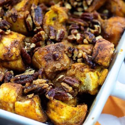 French toast squares and pecans in a white baking pan.