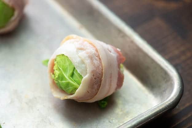 brussels sprouts wrapped in bacon on baking sheet