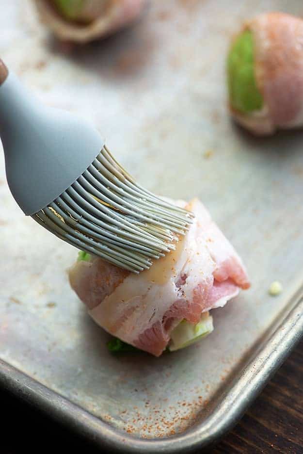 brussels sprouts wrapped in bacon with maple syrup on baking sheet