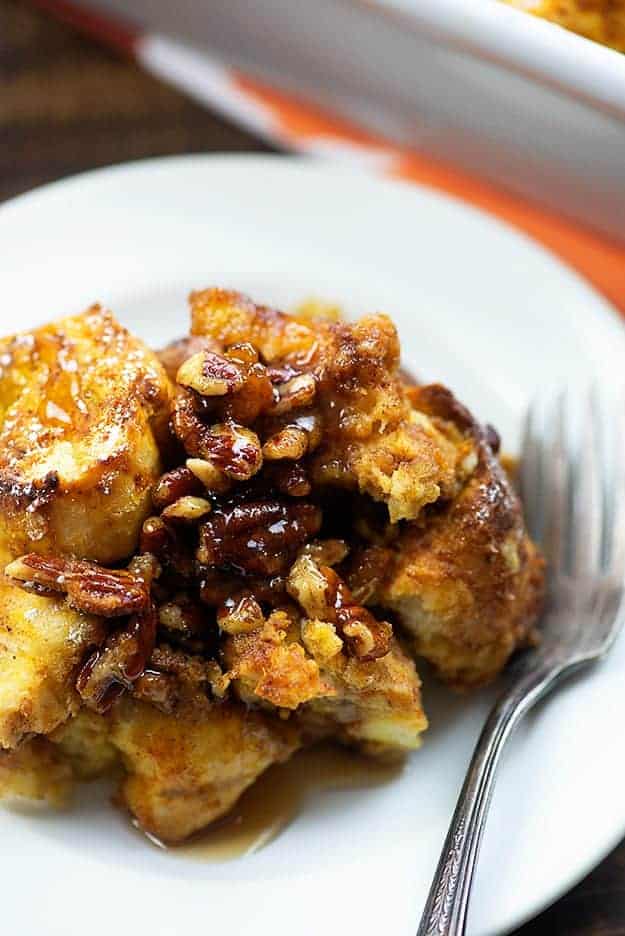 A plate of chopped pecans and french toast squares on a white plate.