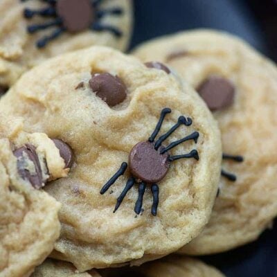 A close up of stacked cookies with chocolate chips.