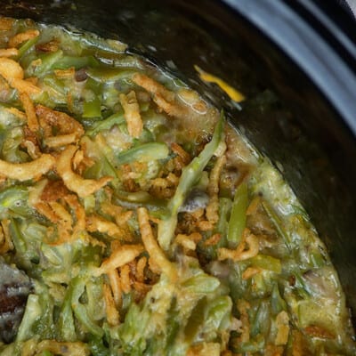 A close up of a crockpot with green beans.