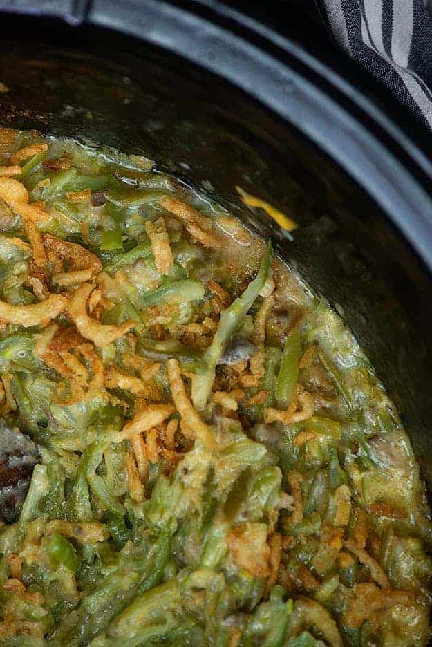 A close up of a crockpot with green beans.