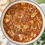 Overhead view of cabbage soup in white pot.