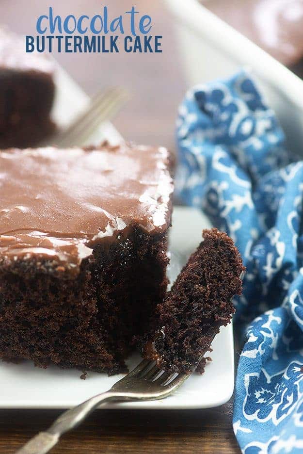 A piece of chocolate cake on a plate with a fork on it.