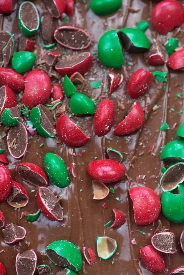 close up of chocolate frosting topped with pieces of M&M\'s.