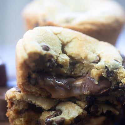 Stacked cookies cut in half displaying melted chocolate and caramel in the middle.