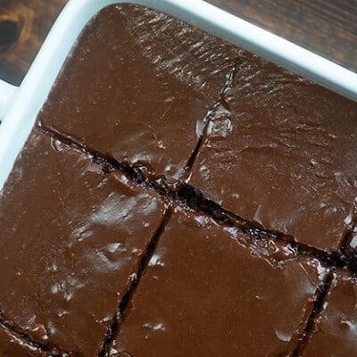 Chocolate cake cut into squares in a cake pan.