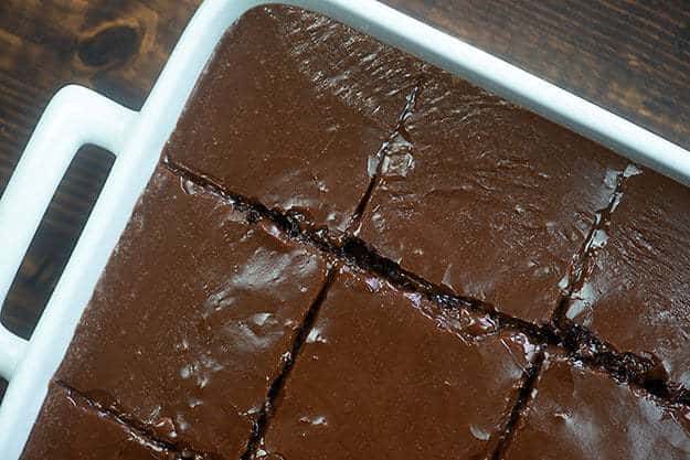 Chocolate cake cut into squares in a cake pan.