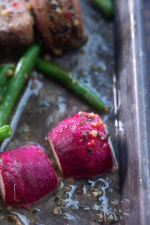 A close up of radishes on a baking sheet.