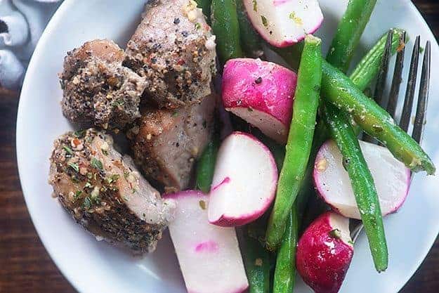 Close up of pork, radishes, and green beans.