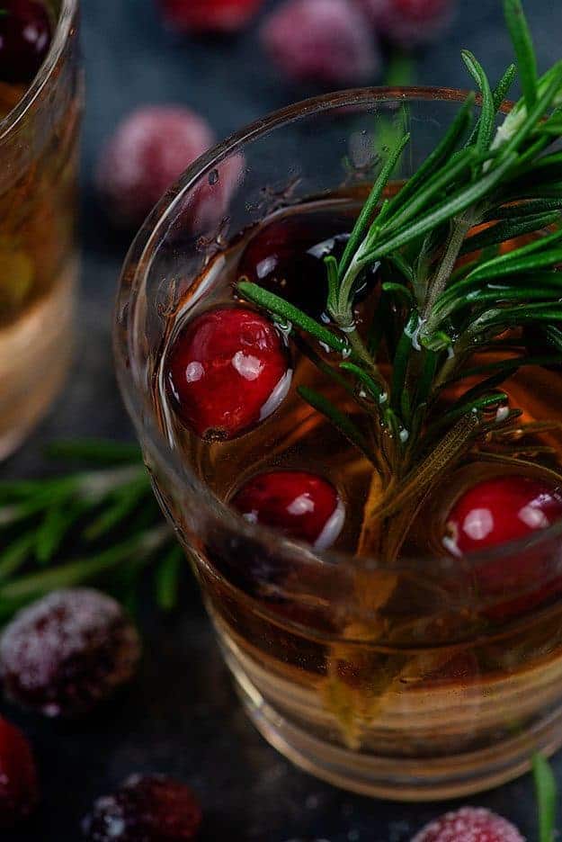 Rosemary and cherries in a glass of sangria.