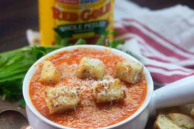 The bull of tomato soup in front of a can of tomatoes 