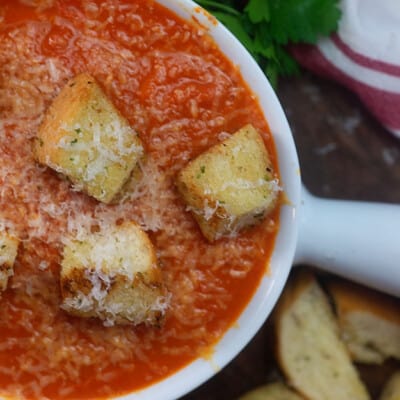A bowl of soup with croutons on top