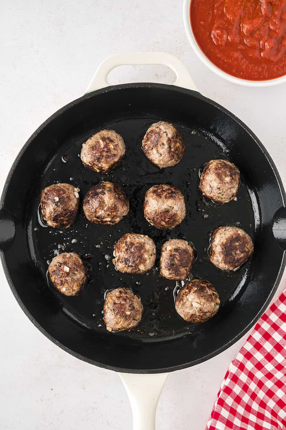 Meatballs being browned in skillet.