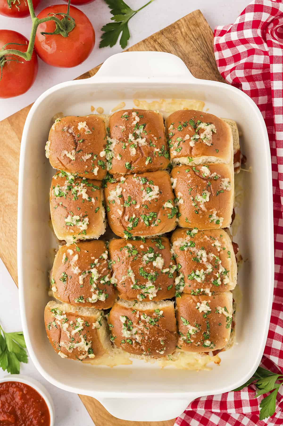 Garlic butter meatball sliders on hawaiian rolls in baking dish.