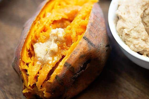A close up of sweet potato topped with honey butter.