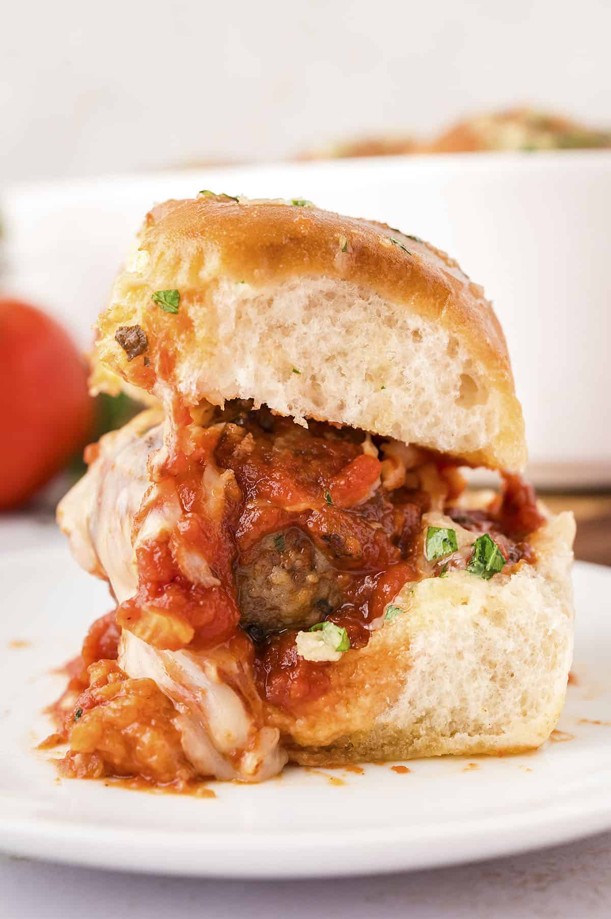 Meatball slider on white plate.