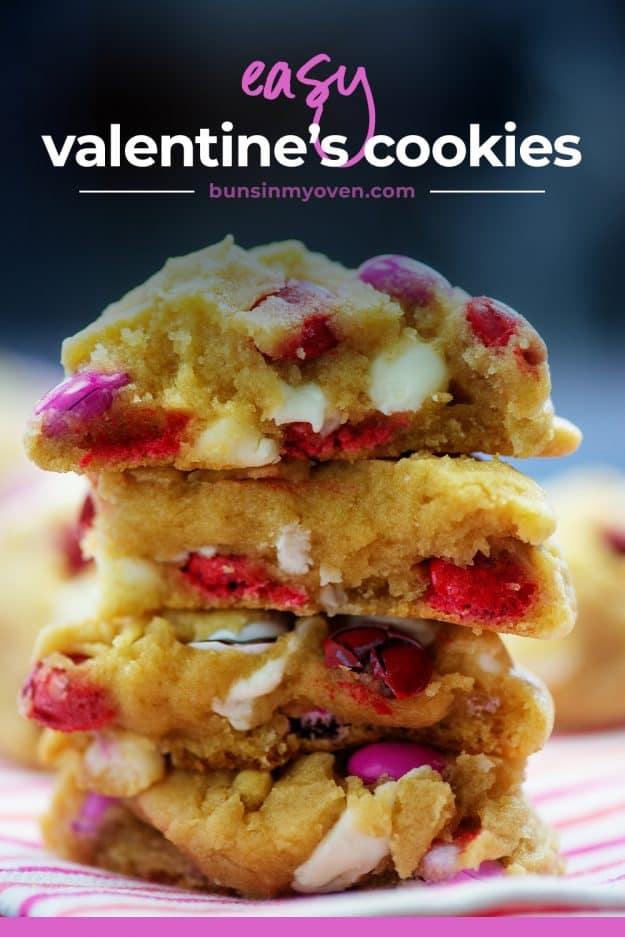 stack of Valentine's Day cookies on striped napkin.